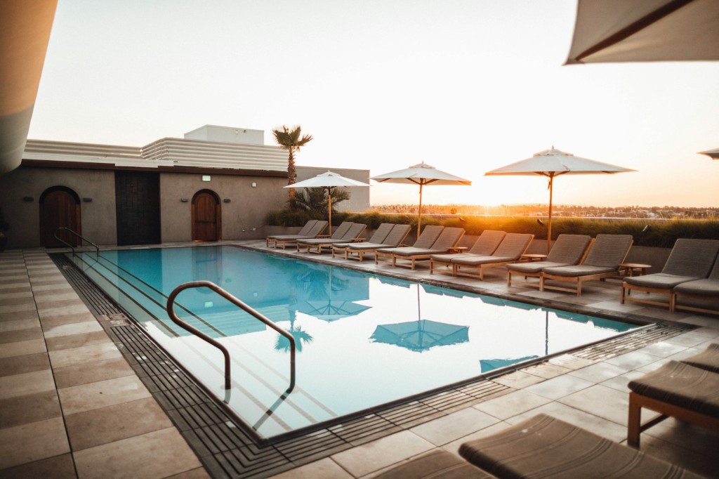 Rooftop swimming pool at sunset with lounge chairs